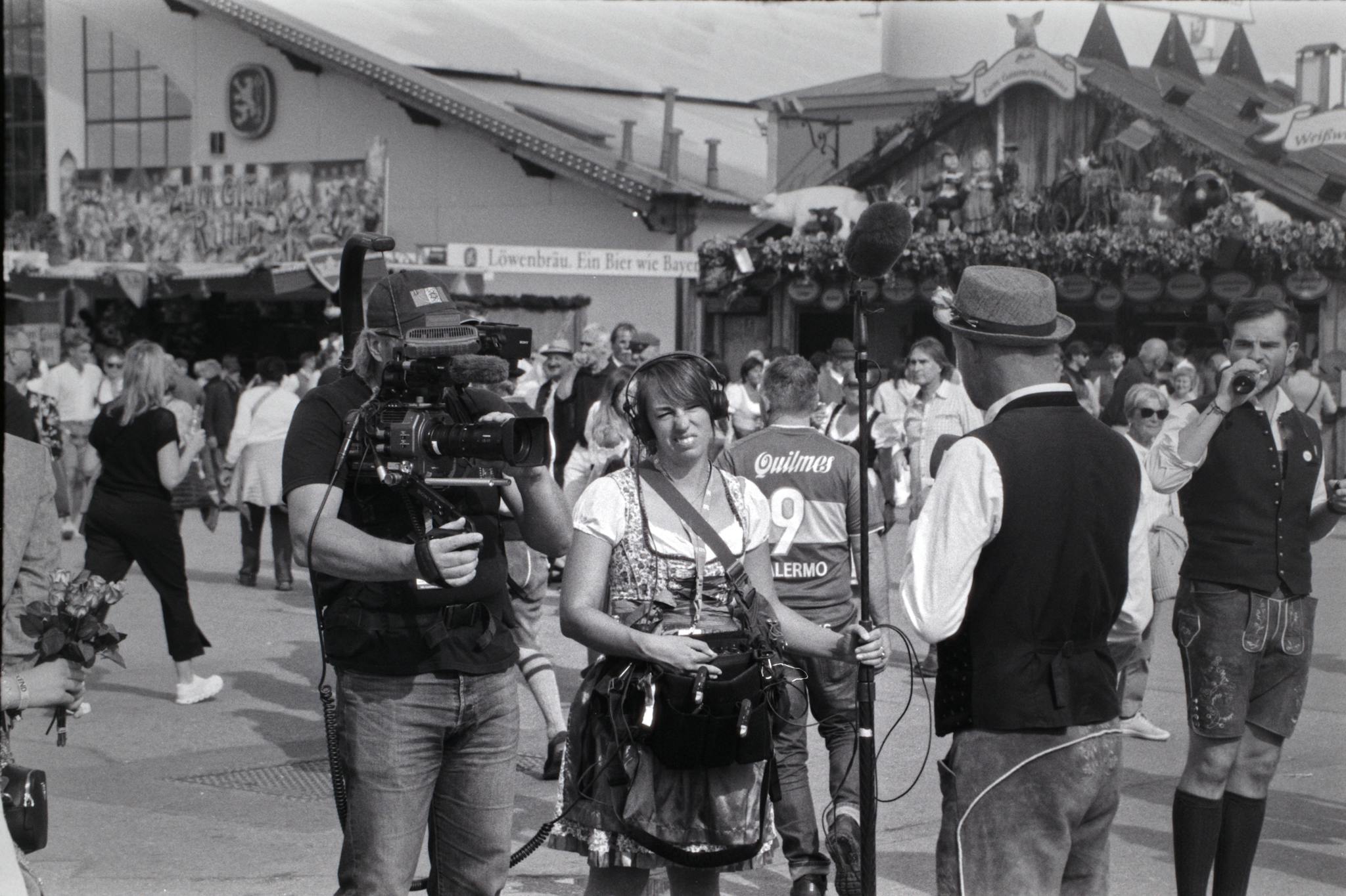 Photo by Alex Moschopoulos Black and white photo of Oktoberfest capturing people in traditional Bavarian attire.
