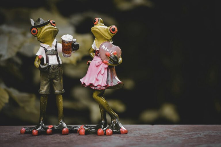 Whimsical frog figurines dressed in Oktoberfest attire with a humorous touch.